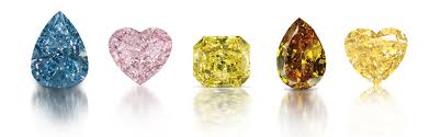 A range of fancy coloured diamonds: blue, pink, and yellow.