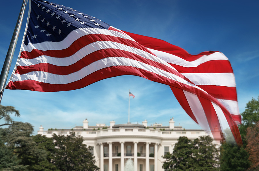 An American flag in front of the White House