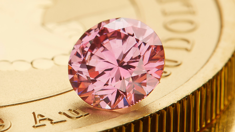 A pink diamond on a gold coin.